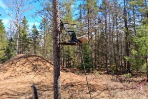 Wooded 8-acre property for sale in Rhinelander with mature trees, direct access to adjoining Wisconsin State Land, and 30x50 concrete pad ready for construction.