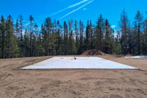 Wooded 8-acre property for sale in Rhinelander with mature trees, direct access to adjoining Wisconsin State Land, and 30x50 concrete pad ready for construction.